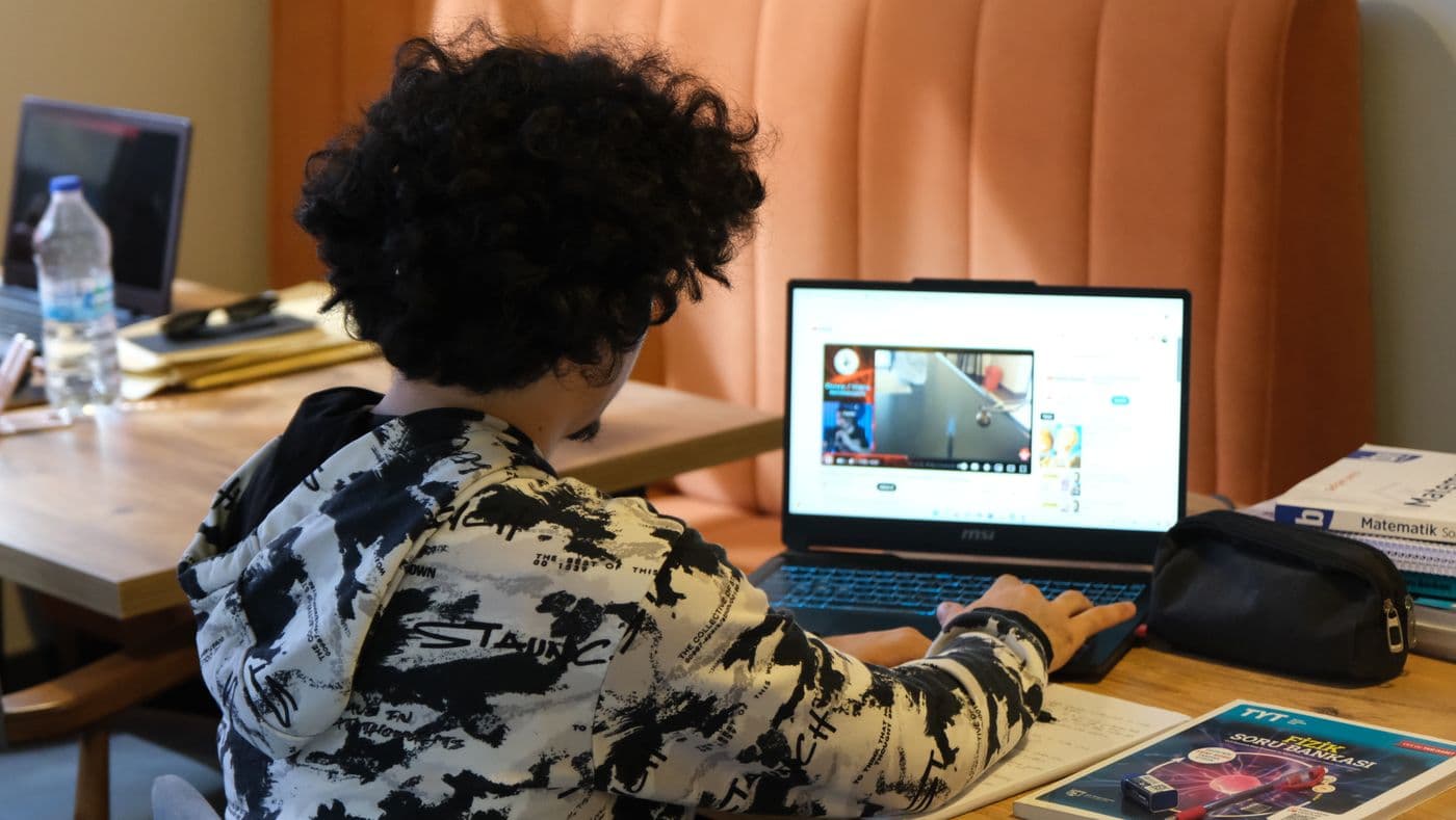 Teenager studying at home surrounded by materials