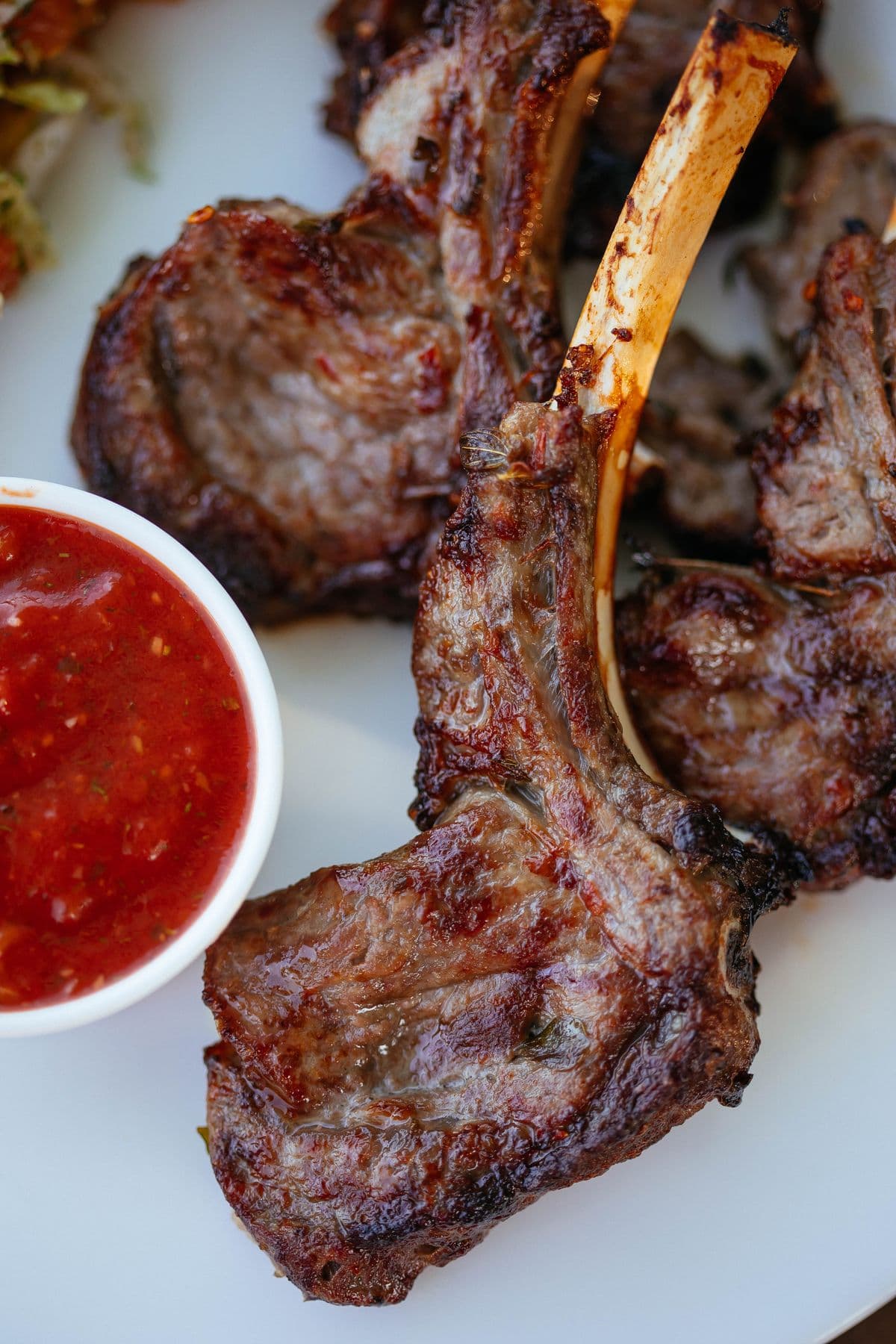Grilled lamb chops plated with a rich red sauce
