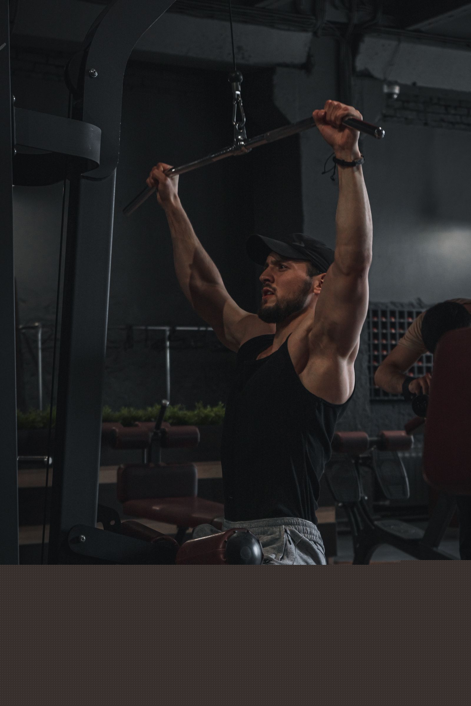 Coach spotting a lat pulldown
