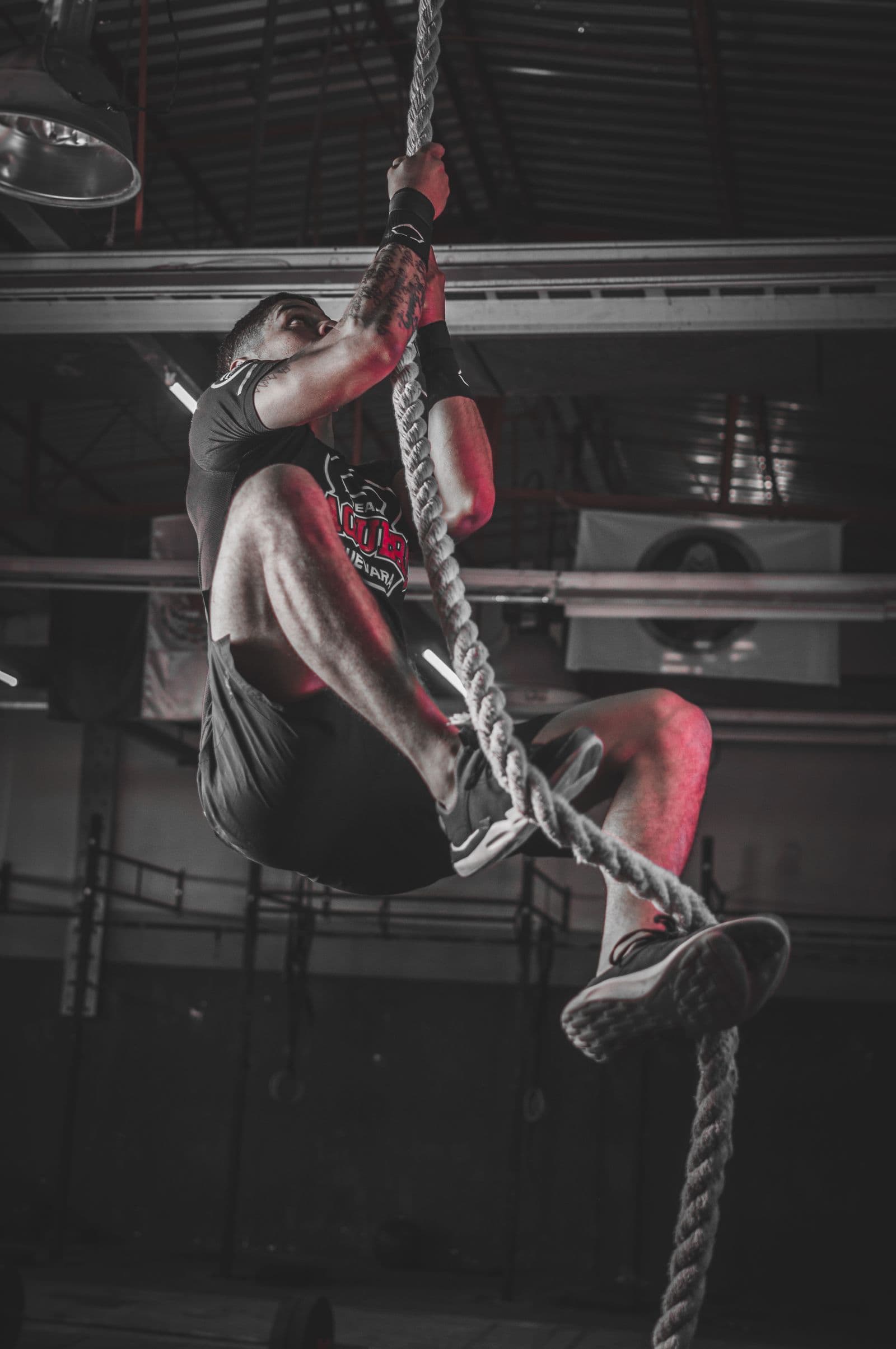 Athlete climbing a rope on the rig